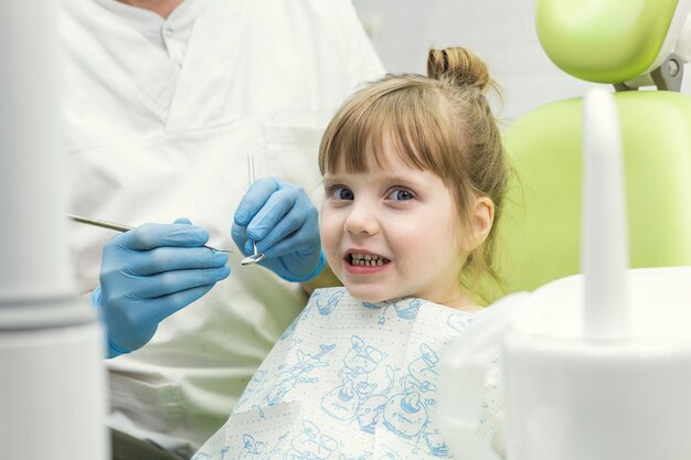 Dentiste examinant les dents de la petite fille à la clinique Problème dentaire