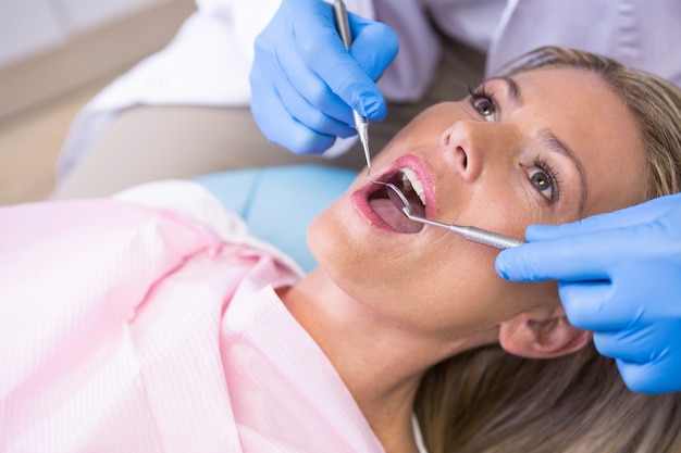 Dentiste examinant la femme à la clinique médicale