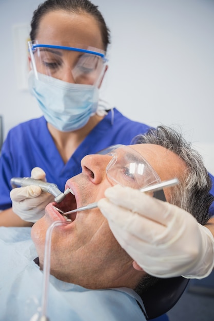 Dentiste examinant un patient avec des outils