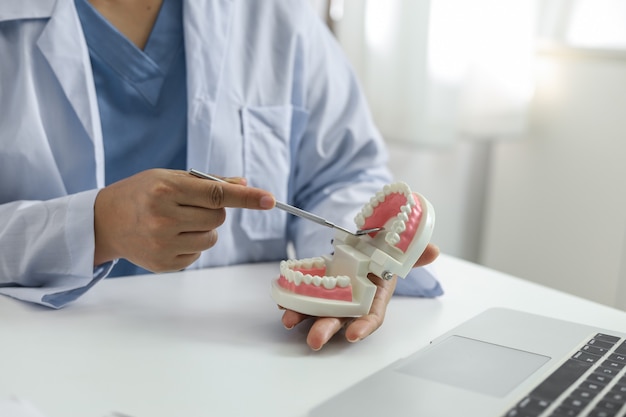 Photo dentiste examinant un traitement médical des dents du patient à la clinique dentaire