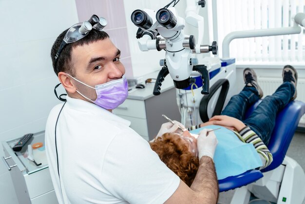 Le dentiste examine les dents au microscope