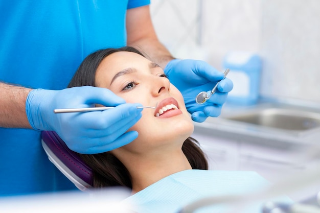 le dentiste examine les dents du patient chez le dentiste.