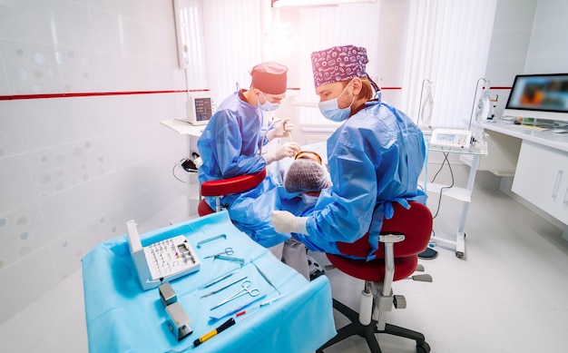 Le dentiste examine les dents du patient pour le traitement ultérieur