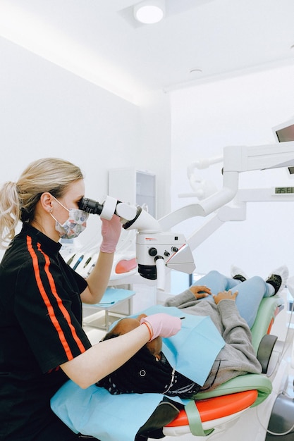 Photo un dentiste examine les dents d'un patient.