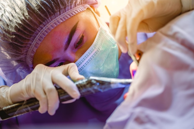 Le dentiste examine les dents des patients en clinique pour une meilleure santé dentaire et un sourire éclatant Le dentiste gratte le calcaireOutils et équipement du dentiste