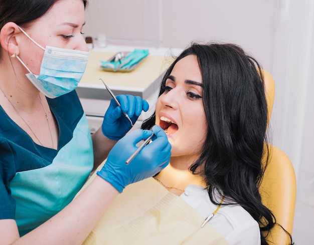 Photo dentiste examine les dents des patients