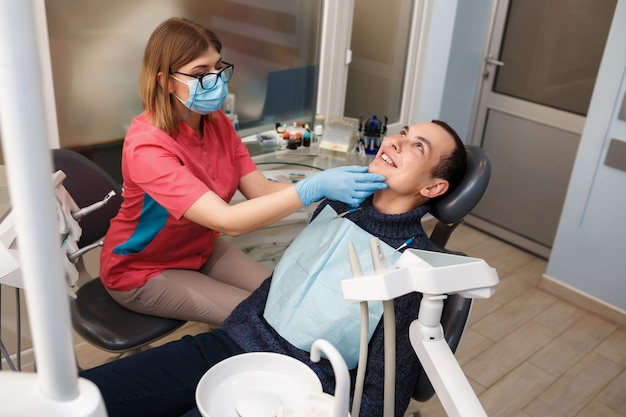 Un dentiste examine les dents de son patient. Action à la clinique dentaire