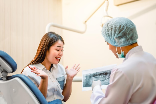 Le dentiste examine les résultats de la radiographie dentaire du patient pour un traitement efficace et améliore la santé dentaire du patient et un sourire éclatant