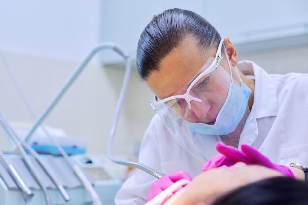 Un dentiste expérimenté traite les dents chez le patient. Technologie, médecine, soins et santé dentaire.