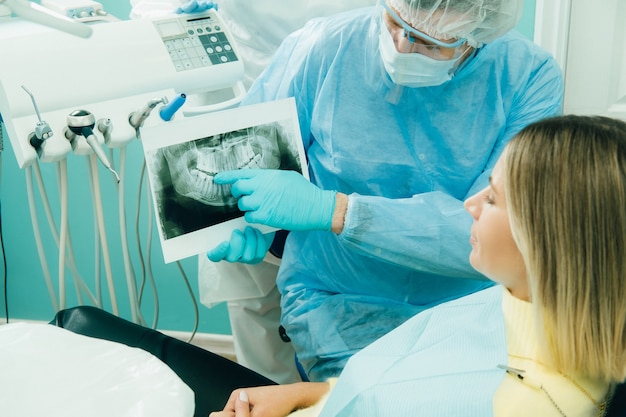 Dentiste expliquant les détails de la radiographie à son patient au bureau.