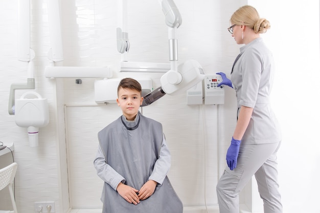 Photo dentiste faire une image radiographique de la mâchoire pour petit garçon dans une clinique dentaire