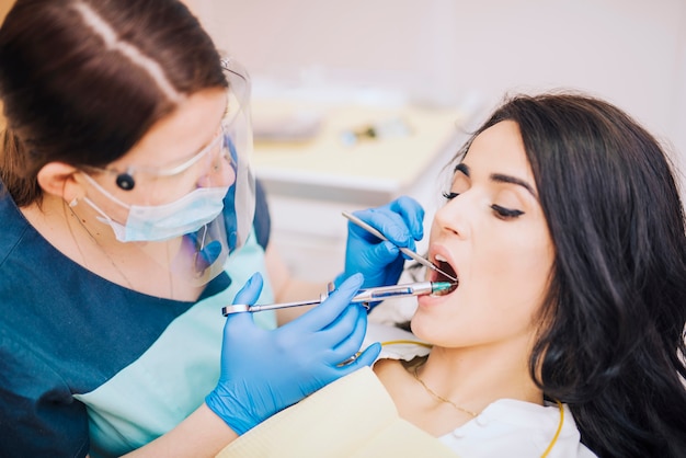 Dentiste faisant une injection anesthésique à une patiente