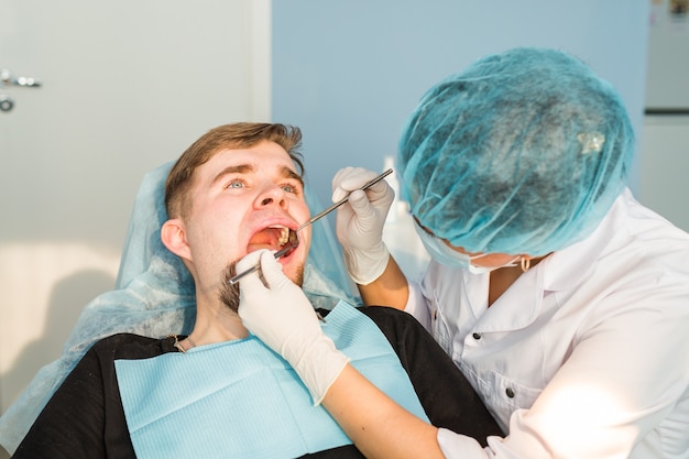 Dentiste faisant un traitement dentaire sur un patient.