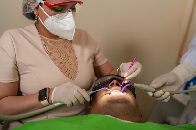 Dentiste féminin examinant la bouche d'un client