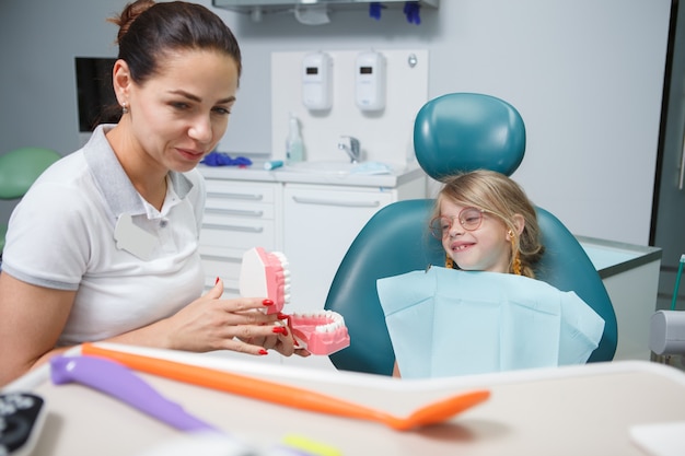 Dentiste féminin travaillant avec son petit patient