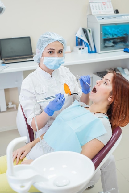 Dentiste féminine obturations dentaires fixes et sèches avec lumière