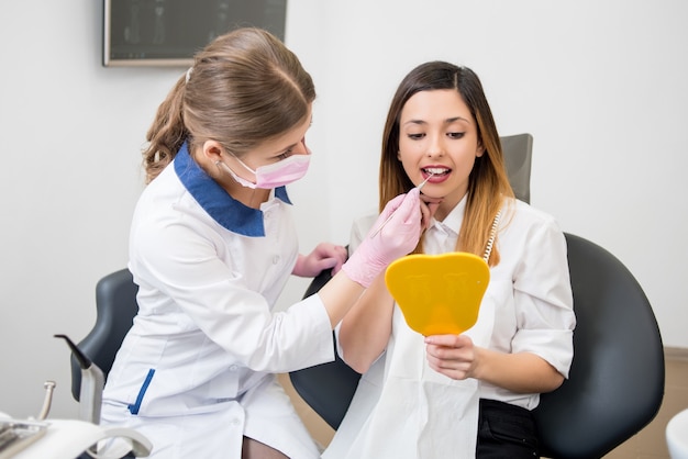 Dentiste femme avec patient au cabinet dentaire