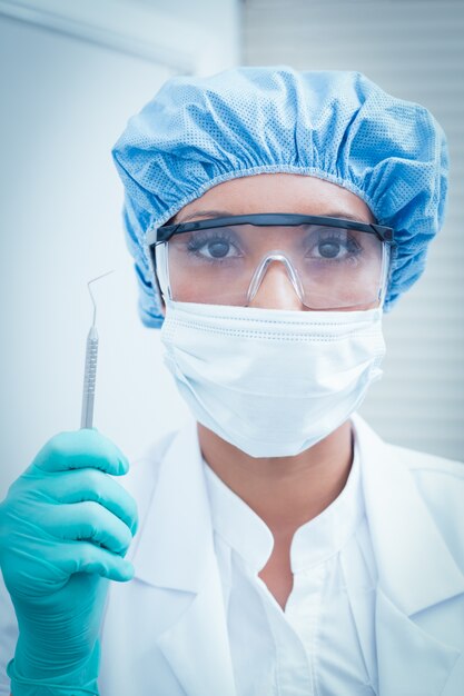 Dentiste femme portant un masque chirurgical et des lunettes de sécurité