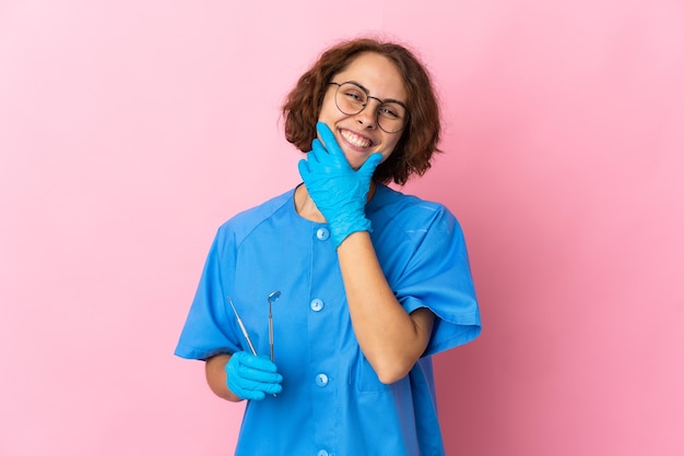 Dentiste femme posant isolé contre le mur blanc