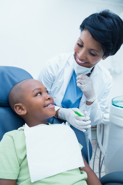 Dentiste femme souriante examinant les dents des garçons