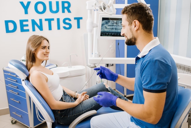 Dentiste homme discutant avec une patiente