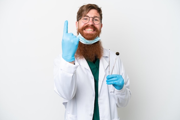 Dentiste homme rougeâtre tenant des outils isolés sur fond blanc faisant un geste à venir