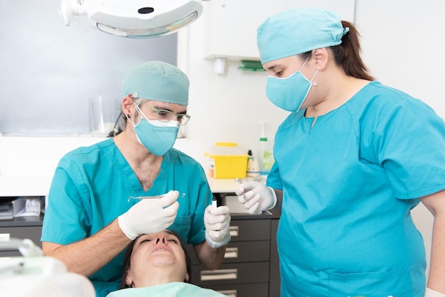 Dentiste et une infirmière auxiliaire soignant un patient