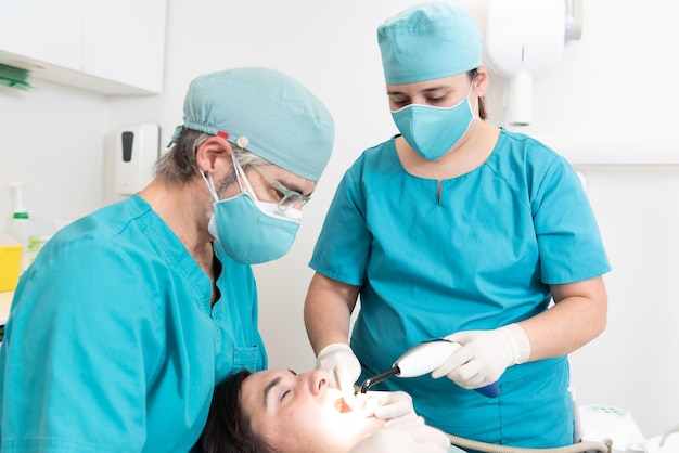 Dentiste et une infirmière auxiliaire soignant un patient