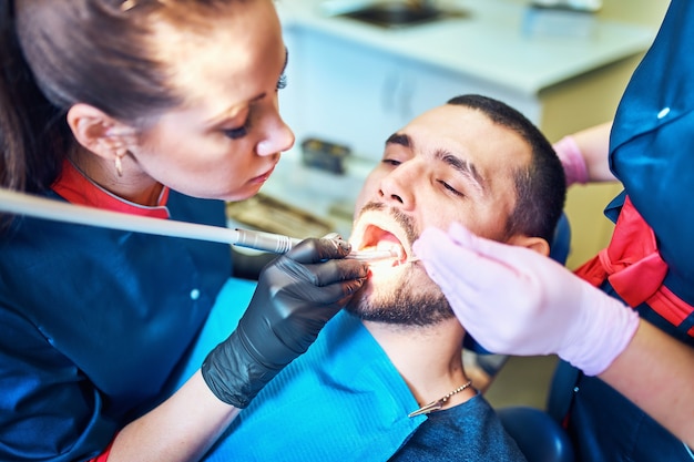 Dentiste et infirmière dentaire à l'aide d'équipement dentaire