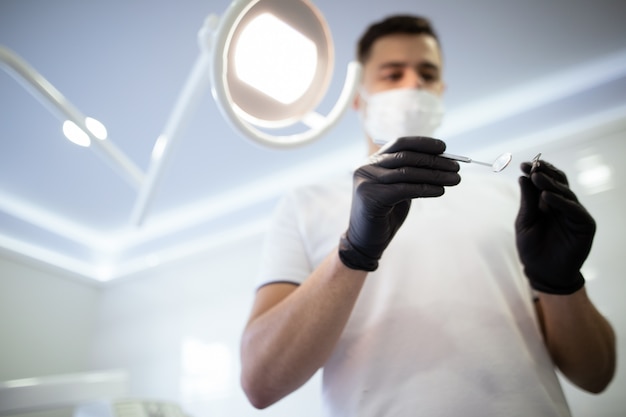 Photo dentiste avec instruments commençant une procédure