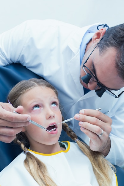 Dentiste mâle examinant les dents des filles