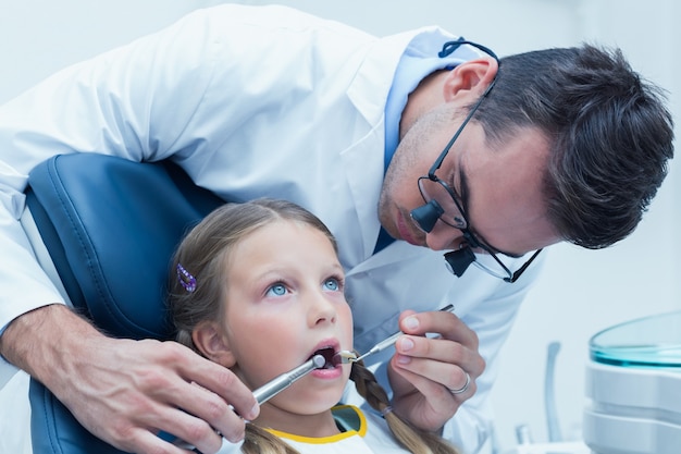 Dentiste mâle examinant les dents des filles