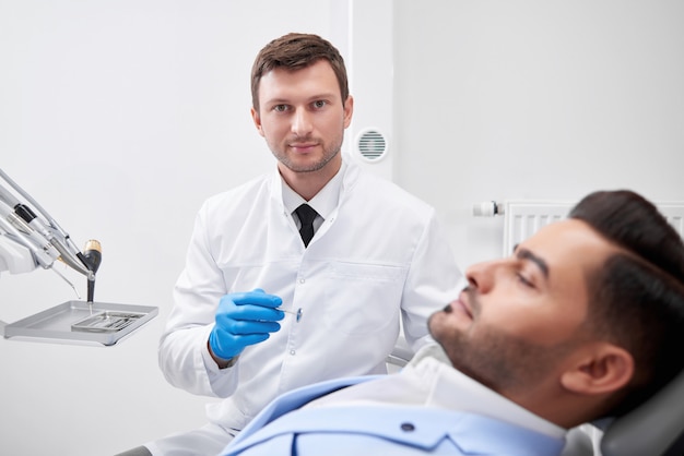 Dentiste mâle mature en toute confiance tout en travaillant avec son patient dentisterie examen oral médecin profession expérience profession concept de médecine de soins de santé.