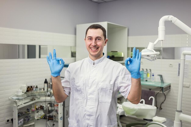 Dentiste masculin debout sur fond de cabinet médical Concept de stomatologie et de médecine de la profession de la santé