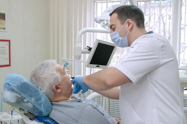 Dentiste Masculin Faisant Des Moulages De Dents De Patients âgés Pour Fabriquer Des Prothèses Amovibles Dans Une Clinique Dentaire