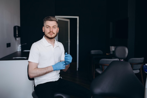 Dentiste masculin mettant ses gants pour travailler avec ses patients