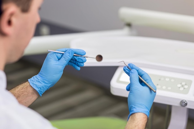 Dentiste masculin avec des outils sur fond de cabinet médical Concept de stomatologie et de médecine de la profession de la santé