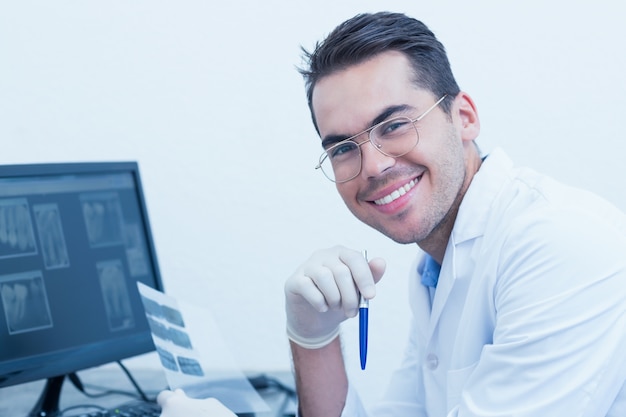 Dentiste masculin avec radiographie sur ordinateur