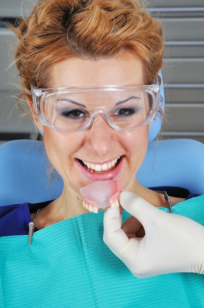 Le dentiste met le dentier