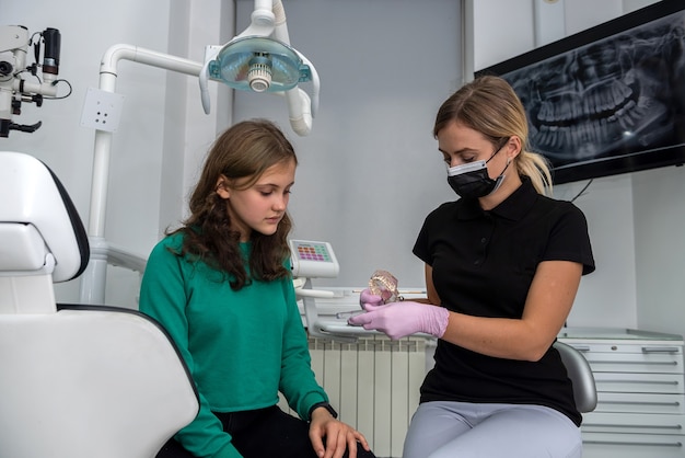 Dentiste montrant comment se brosser les dents