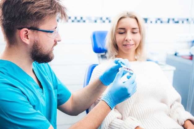 Dentiste montrant le modèle de dents du patient