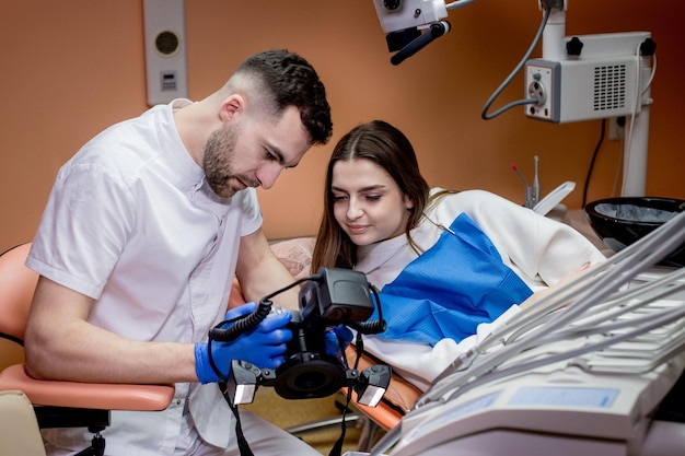 Le dentiste montre au patient une photo du résultat du traitement Patient satisfait