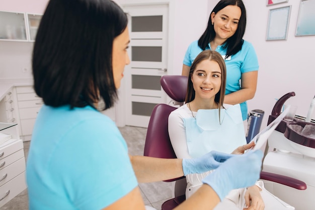 Une dentiste montre à une patiente une photo de sa mâchoire