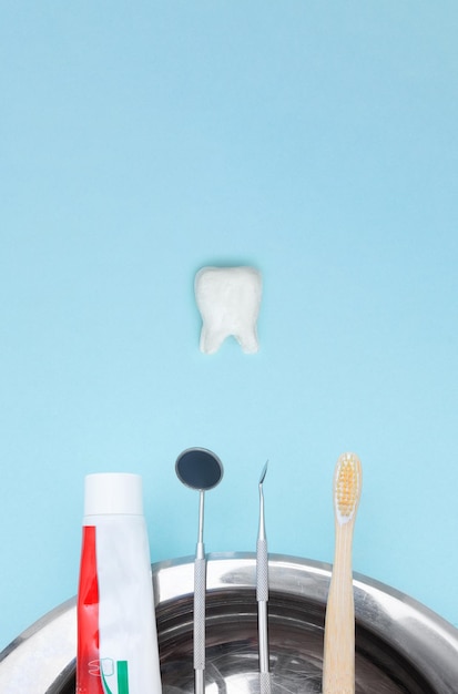 Dentiste outils brosse à dents dentifrice et modèle de dent sur fond bleu équipement dentaire soins dentaires image conceptuelle fond hygiène dentaire concept de guérison