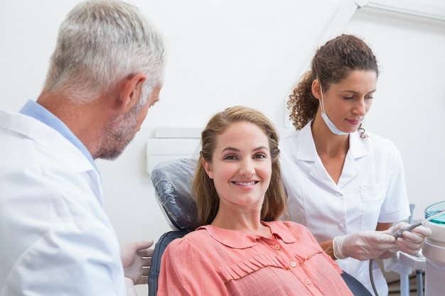 Dentiste parlant avec le patient pendant que l&#39;infirmière prépare les outils