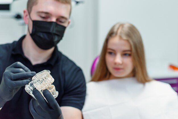 Photo le dentiste parle avec la patiente dans une clinique moderne