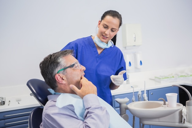 Dentiste parle avec son patient