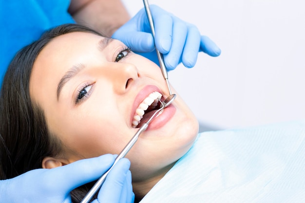 Photo dentiste et patient dans le cabinet dentaire. femme ayant des dents examinées par des dentistes