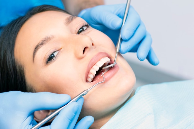 Dentiste et patient dans le cabinet dentaire. Femme ayant des dents examinées par des dentistes