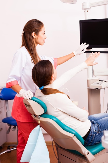 Dentiste avec et patiente regardant un ordinateur